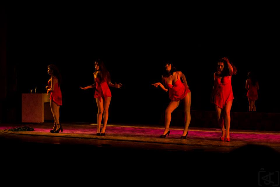 Barraca teatro con cuatro bailarinas jovenes vestidas de rojo en tarima.