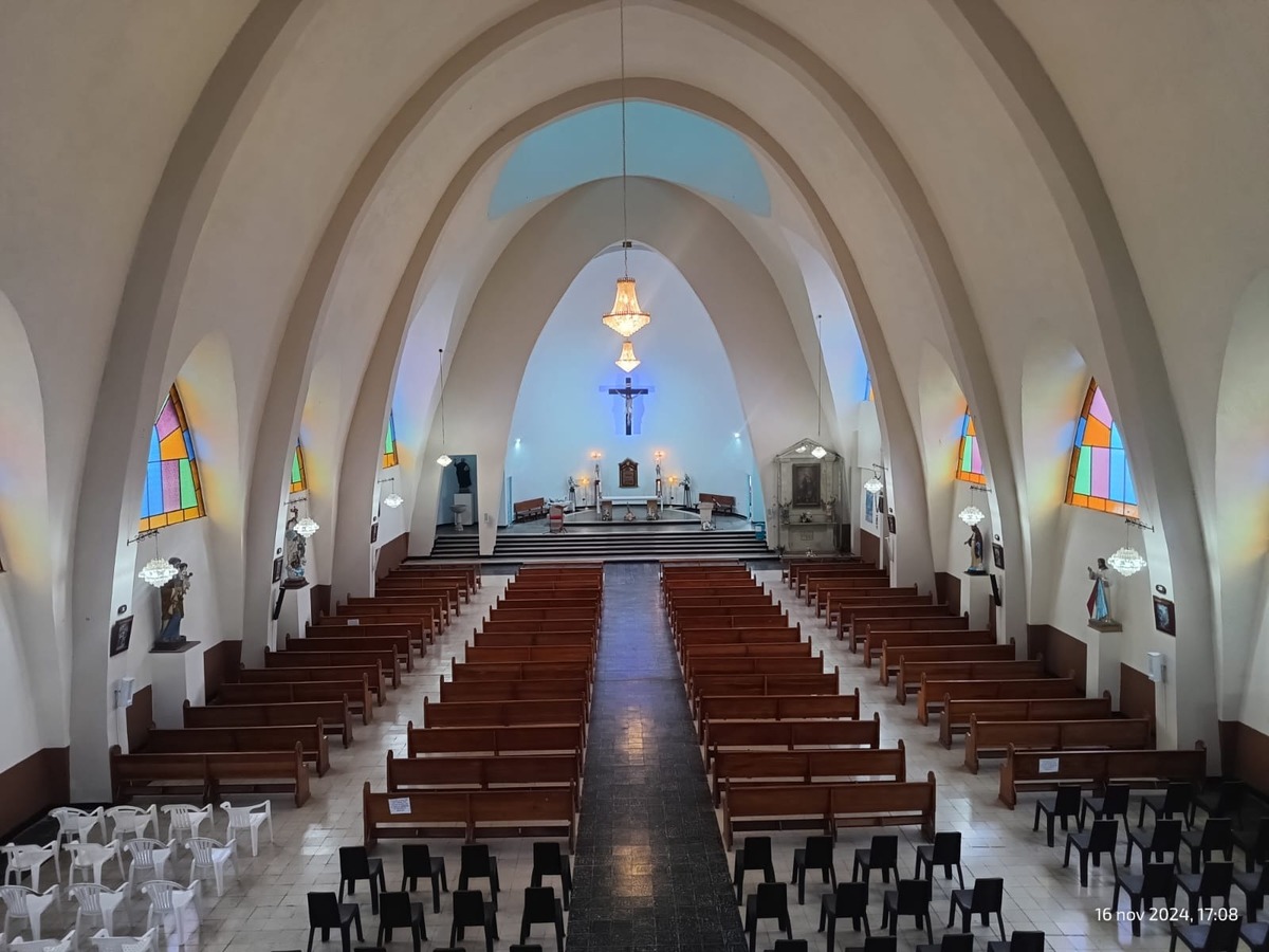 Santurio San Ignacio de Loyola - Supatá interior vacía se observan ovalos en el techo y las sillas completamente vacías. Al fondo de llogra ver la cruz y un par de lámparas.