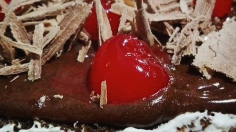 Pedazo de pastel de chocolate con cereza.