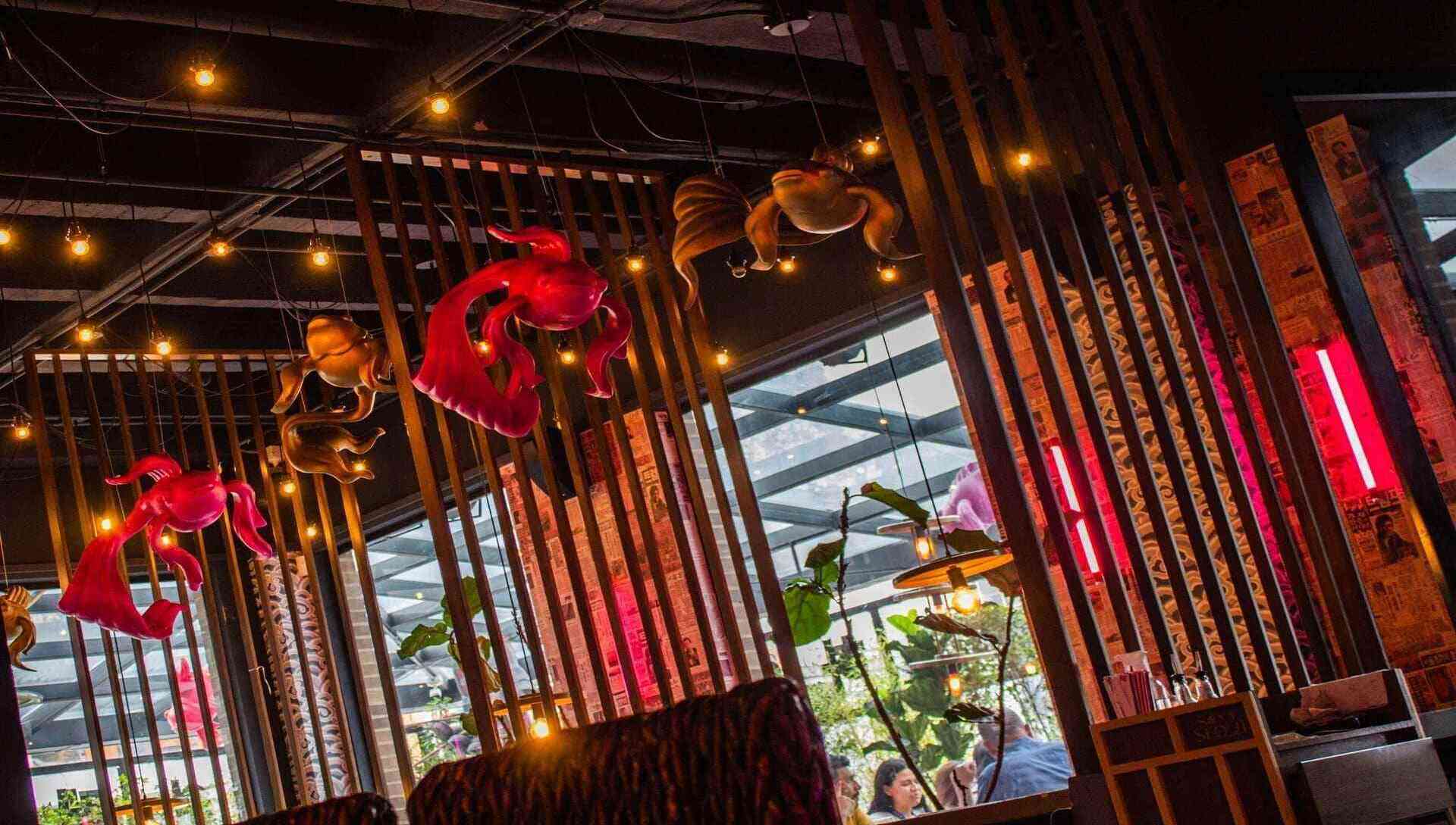 Cuadros de sushi tempurizado con topping de mariscos y salsas, adornados con pétalos rojos.