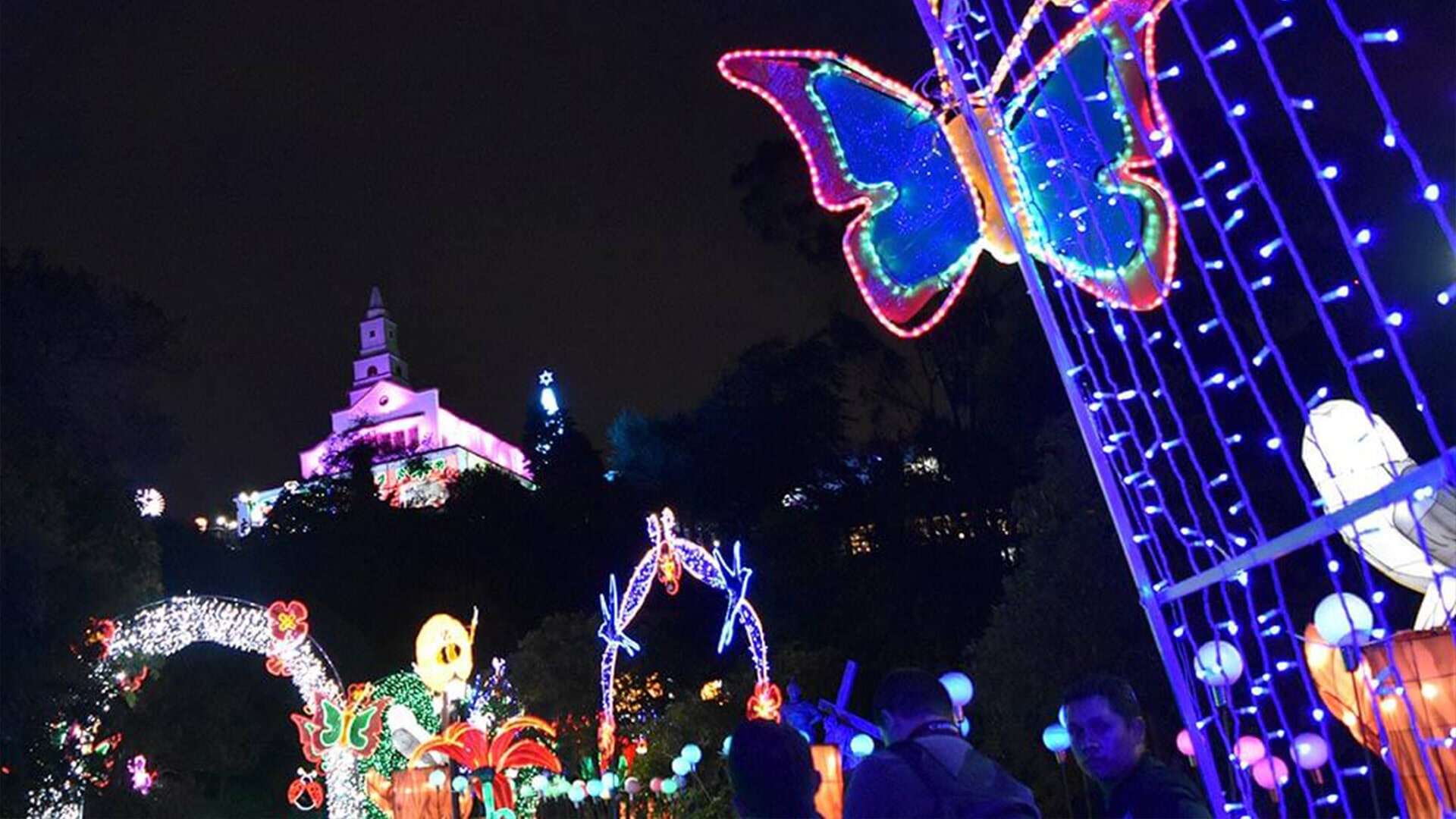  Vista de noche desde abajo a la iglesia de Monserrate iluminada con luces de Navidad.