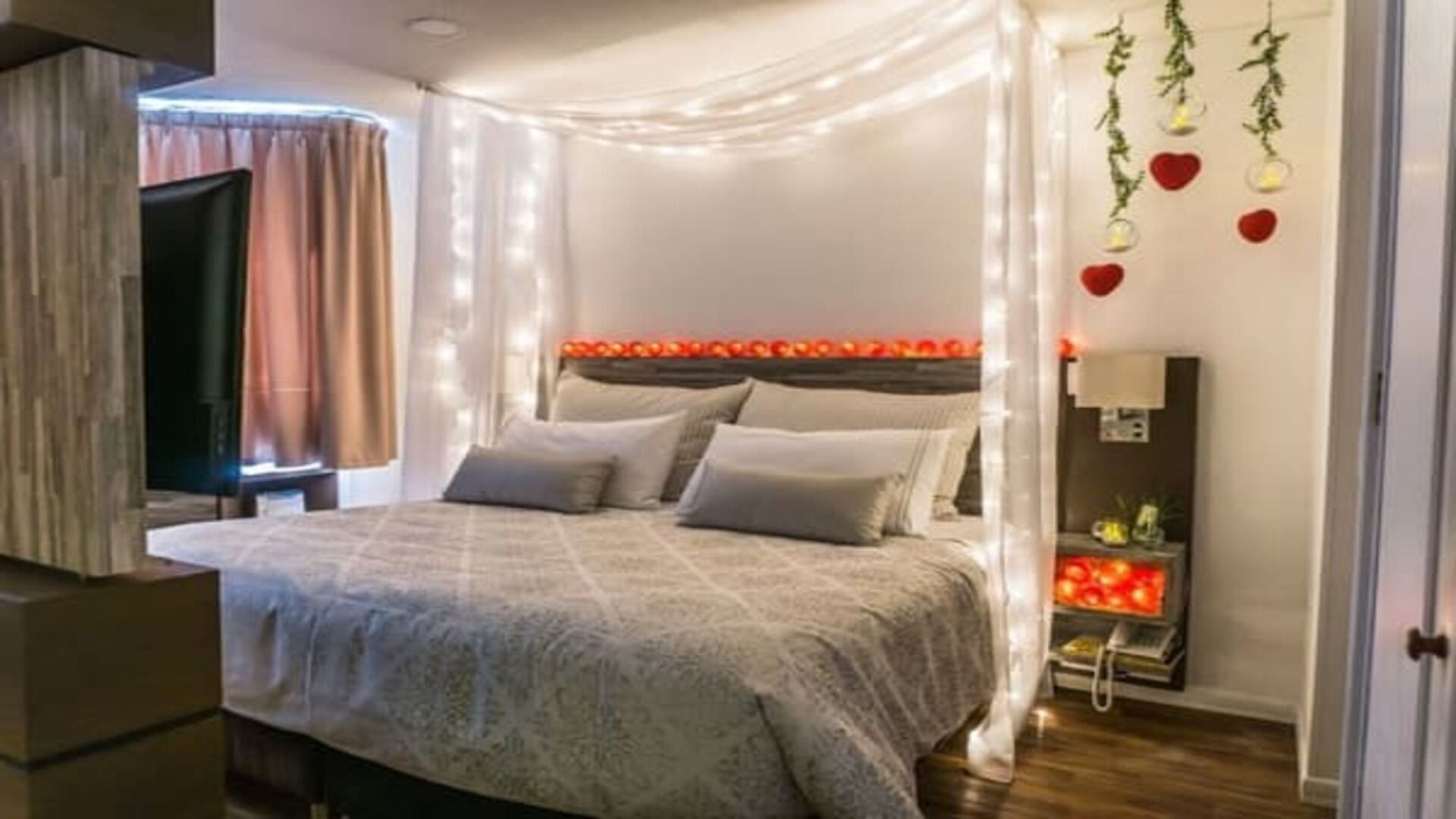  Una suite familiar dividida en dos áreas: una sala de estar con sofá y mesa, y un dormitorio con dos camas individuales. La decoración es sencilla y práctica.