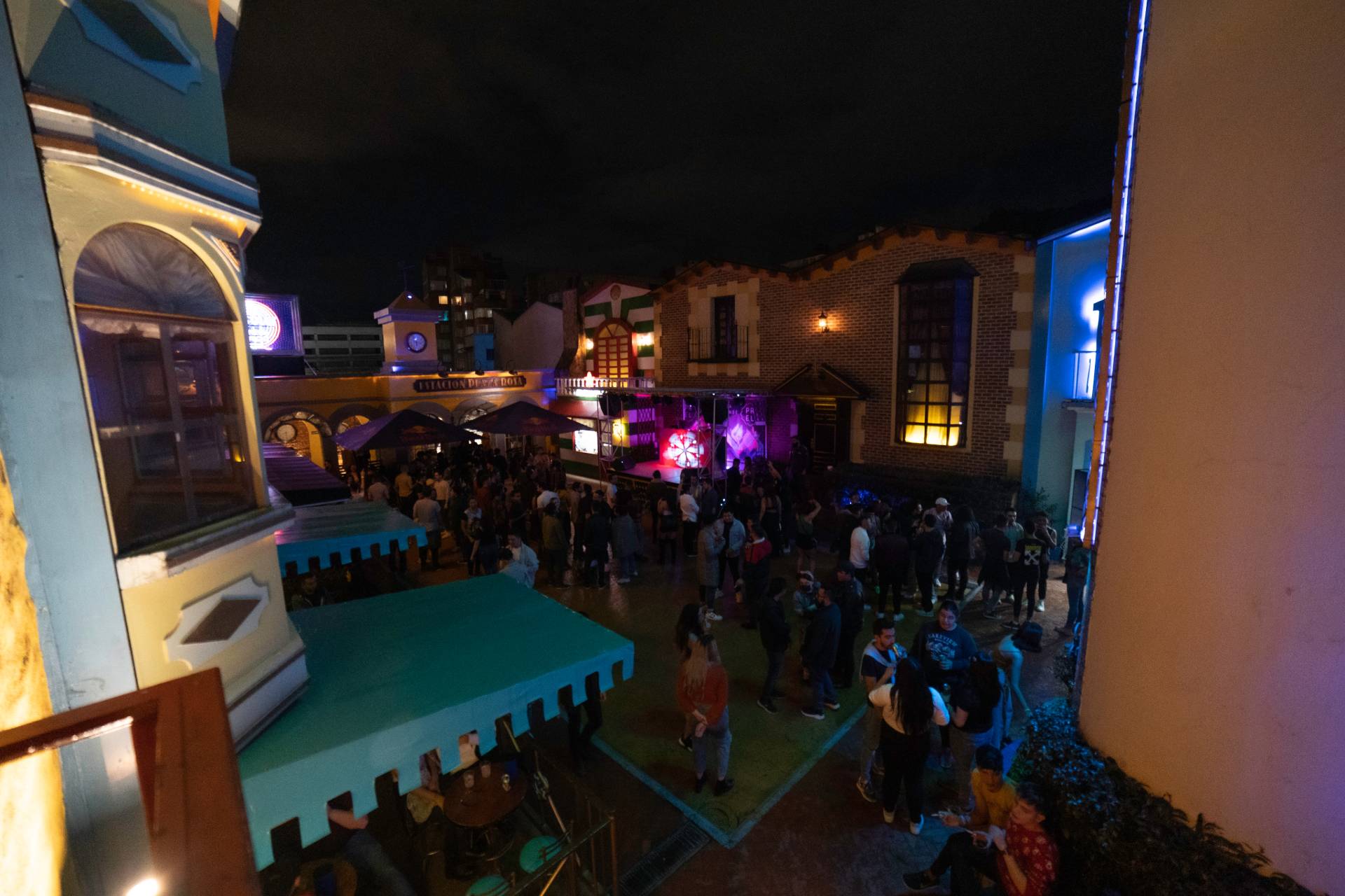 Theatron interior plazoleta de noche con fachadas de castillos y grupo de personas bailando